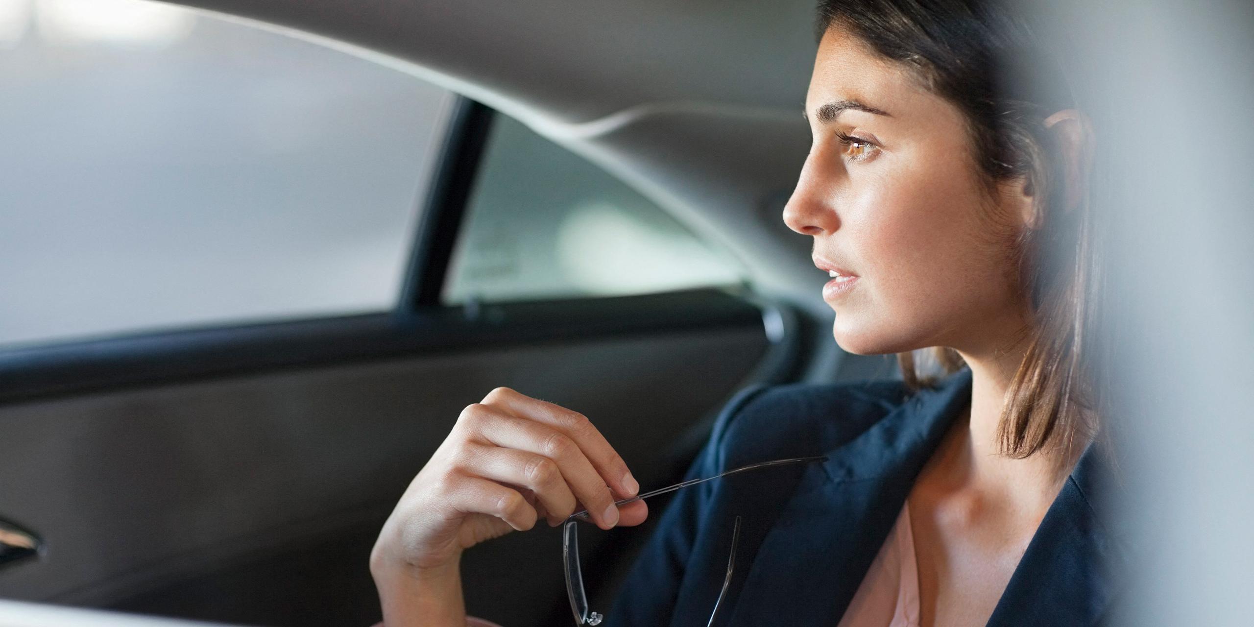 Une femme est assise à l'arrière d'une voiture