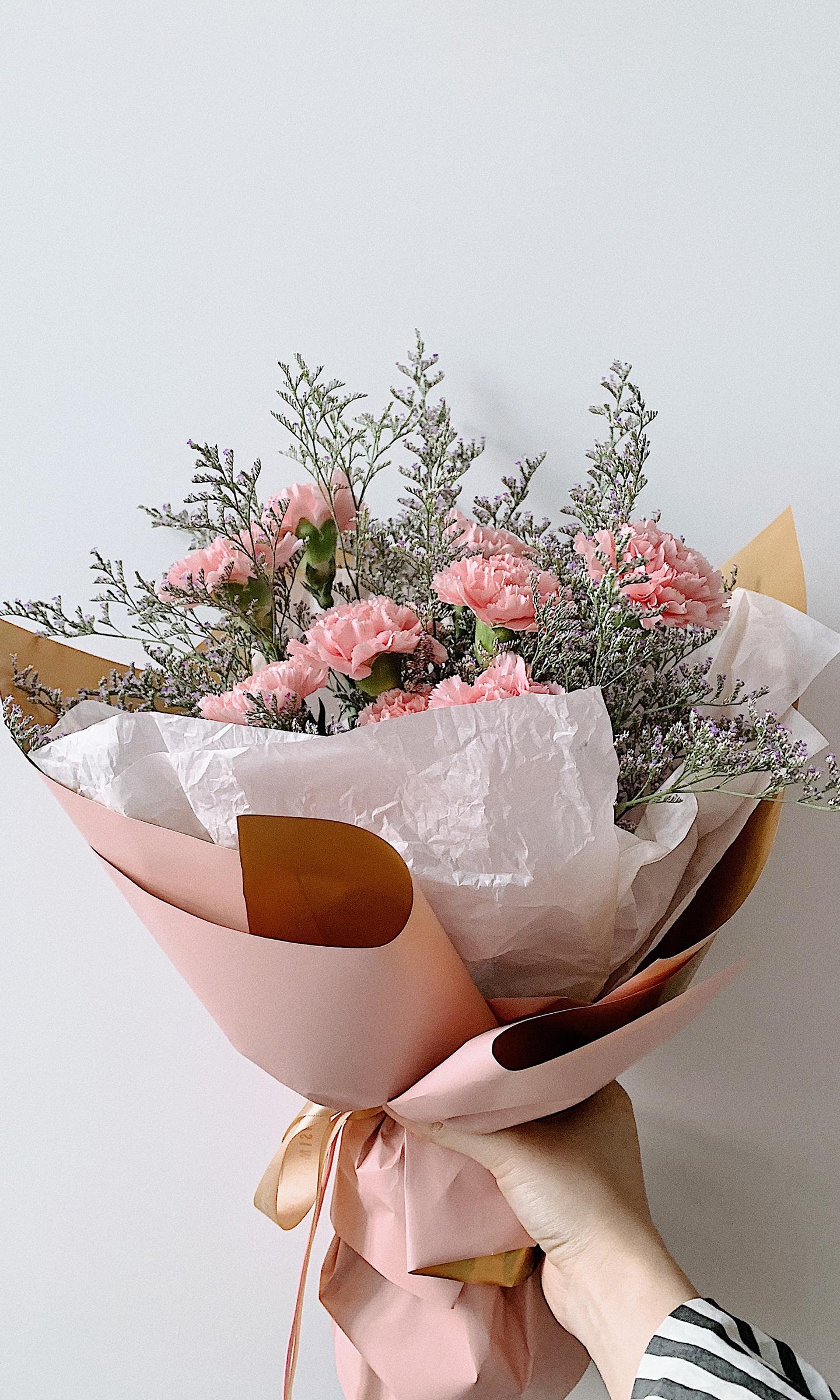 Un bouquet de fleurs est tendu par une main