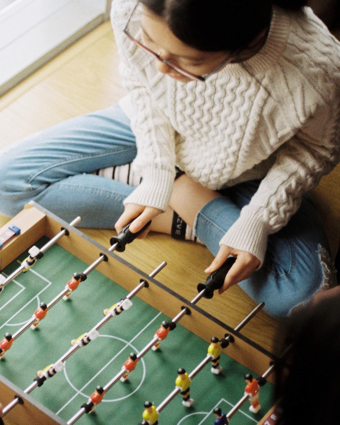 Deux jeunes sont en train de jouer à un mini babyfoot