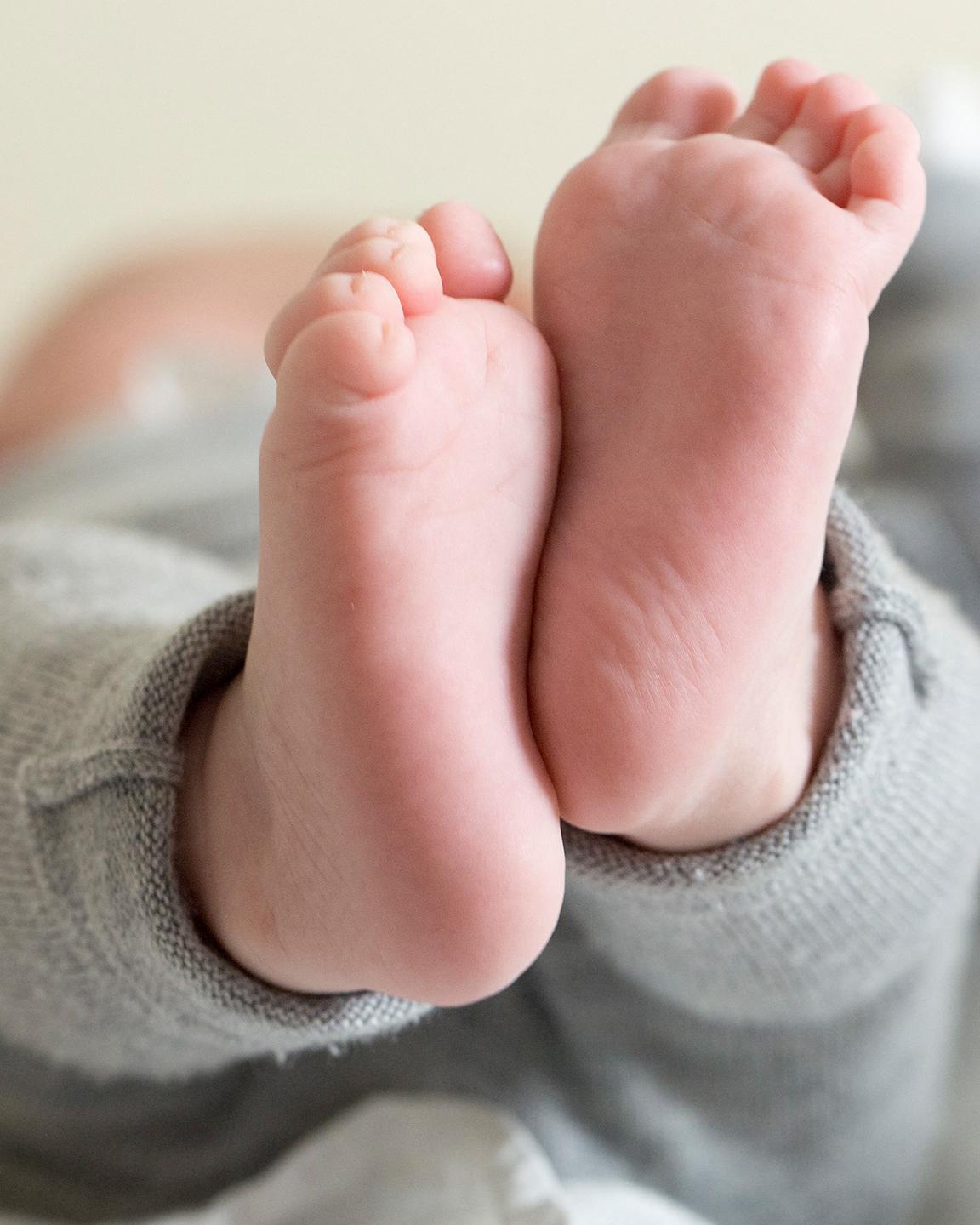 Un bébé est allongé sur un matelas, ses pieds sont au premier plan