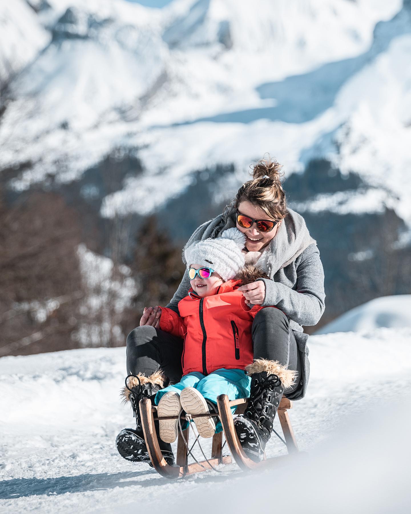 Descente à luge d'une femme avec un enfant au Grand-Bornand