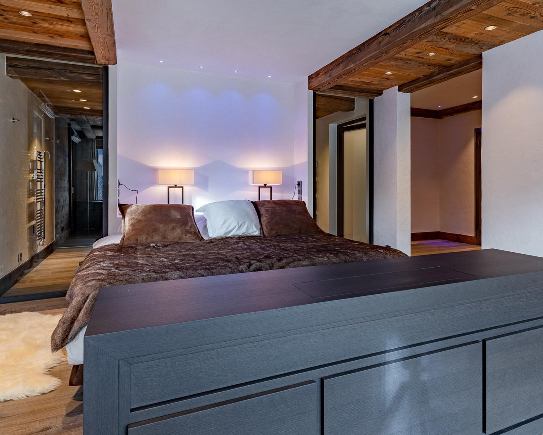 Lit avec derrière la salle de bains privative d'une des suites du Chalet Apsara à Méribel